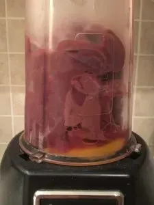 A close-up shot of the liver and egg mixture being blended until smooth in a food processor