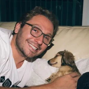 A contented cream miniature dachshund puppy, Butters, enjoying a cozy moment indoors.