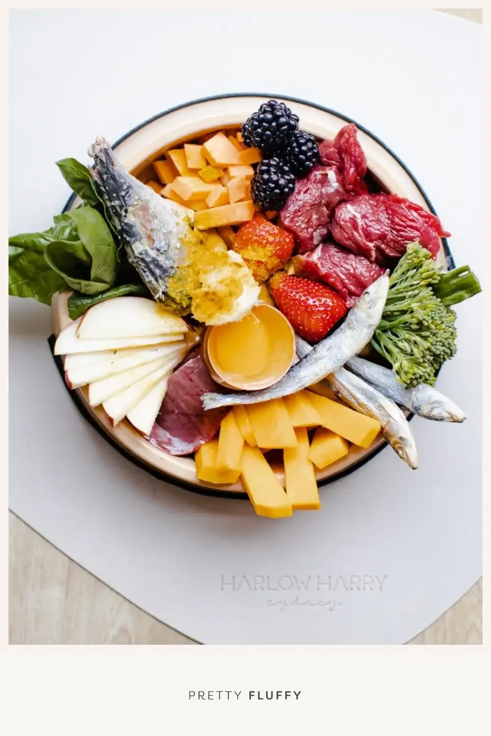 A delicious bowl of raw dog food featuring muscle meat, organ meat, and some vegetables ready for a hungry pup