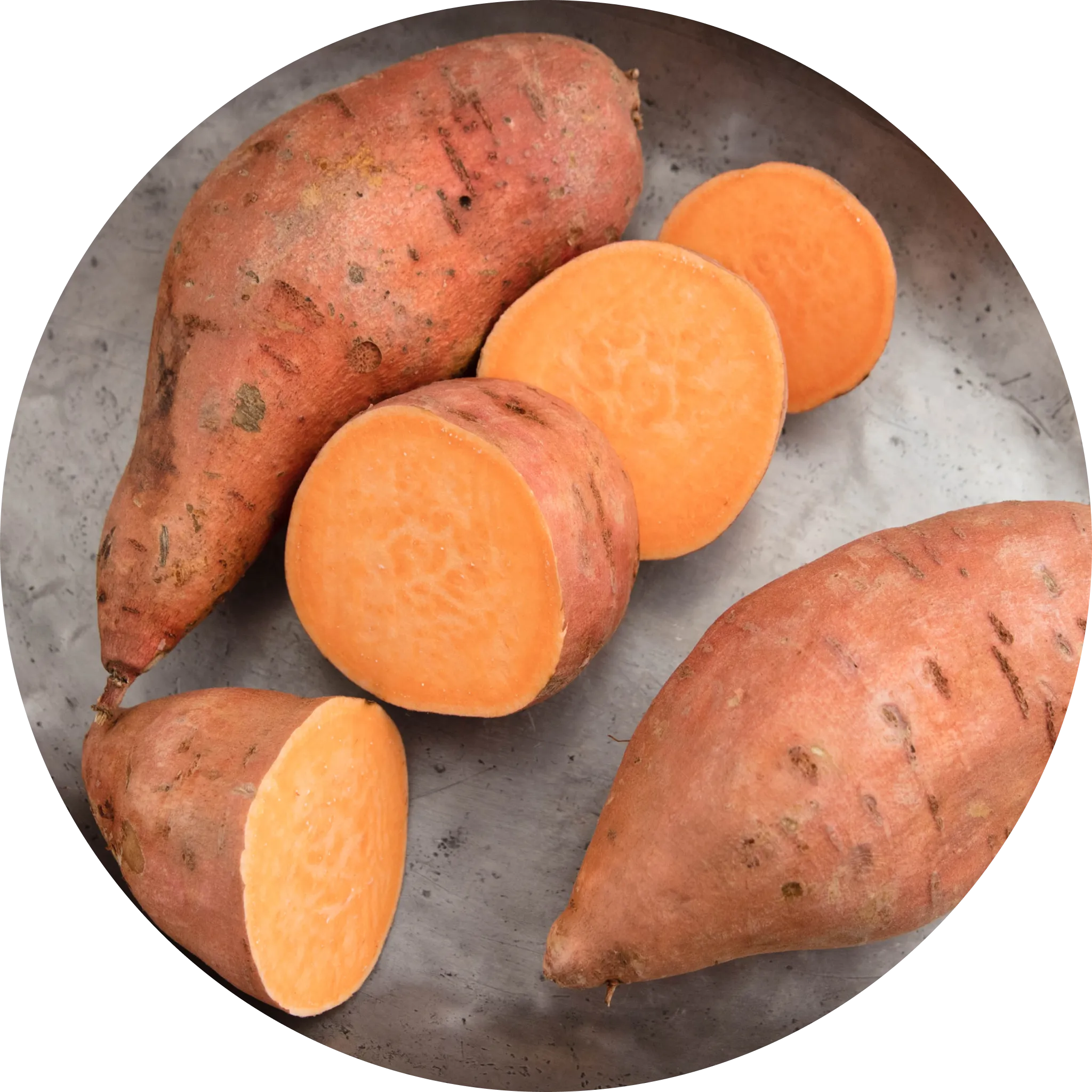 A group of fresh, earthy sweet potatoes with reddish-brown skin clustered together on a clean surface