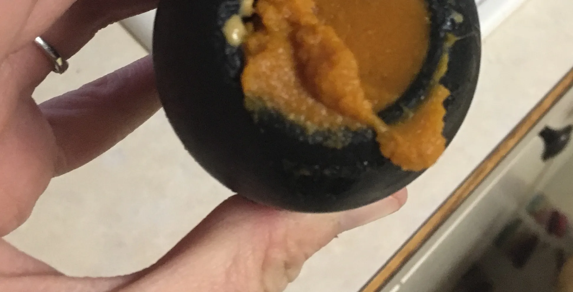 A Kong toy partially filled with soft, mashed food for a dog