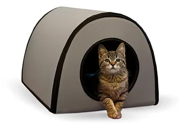 A modern gray heated cat shelter with a unique design, featuring a comfortable heated pad for feline occupants.