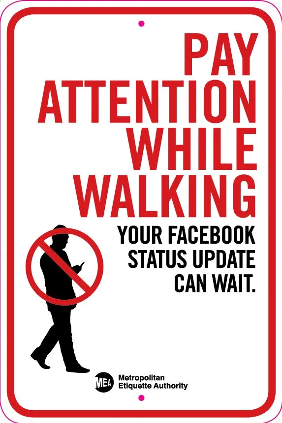 A "Pay Attention" sign from the Metropolitan Etiquette Authority, cautioning against distracted walking.