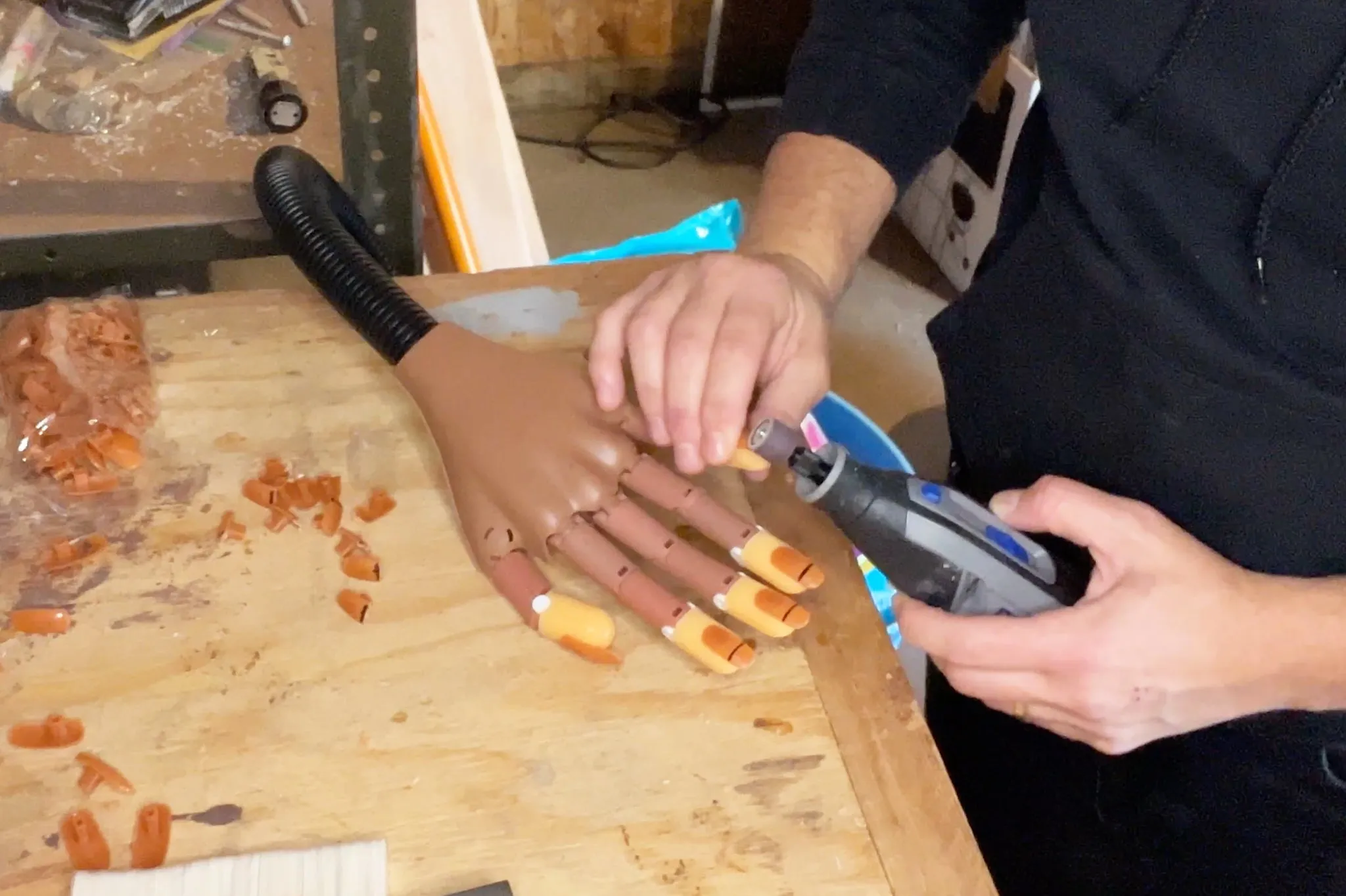 A person using a Dremel PawControl to file the nails of a practice hand.