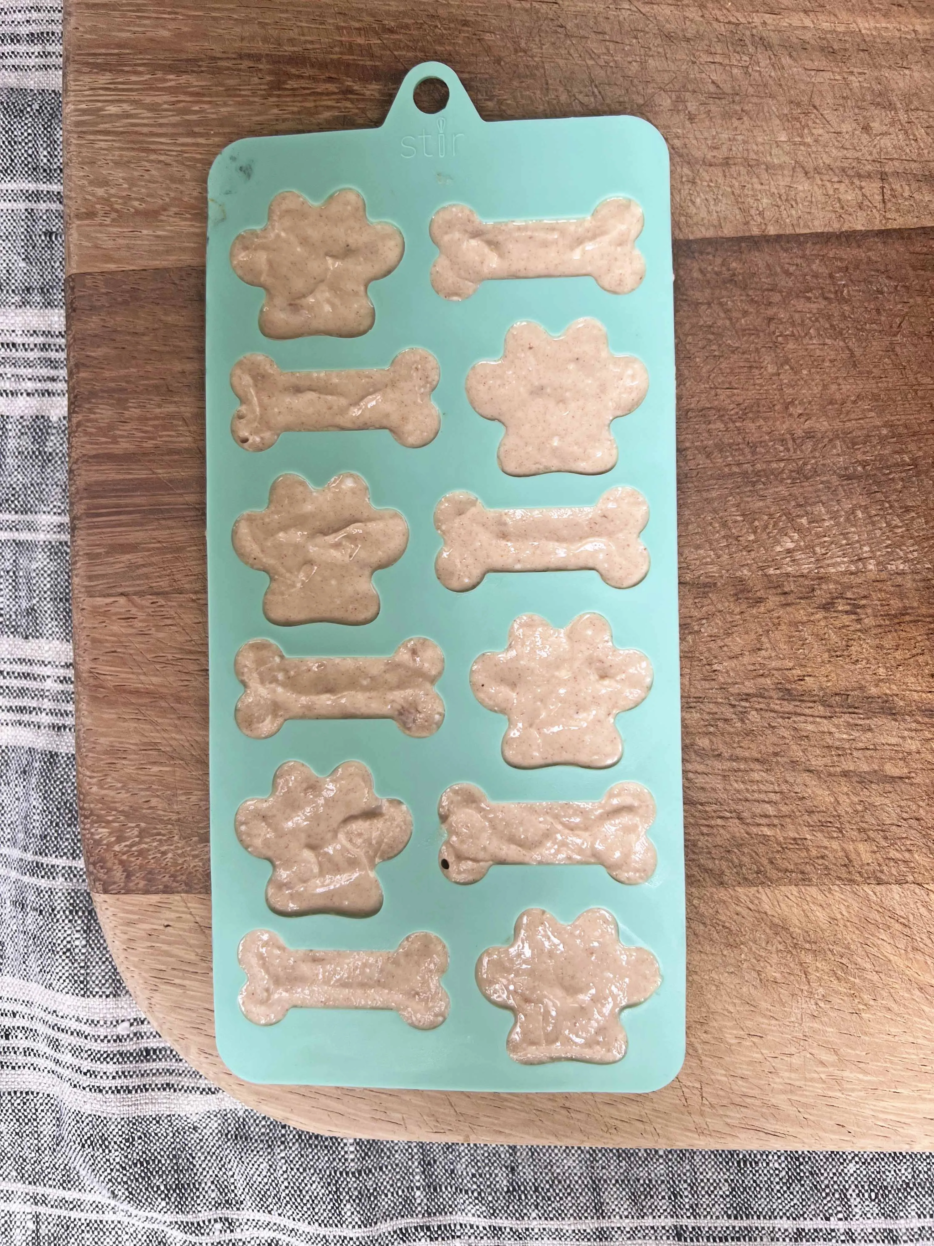 A red silicone mold in the shape of dog paws and bones, perfect for homemade treats