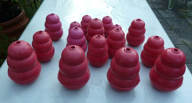 A stack of clean, red and black Kong dog toys, ready for use