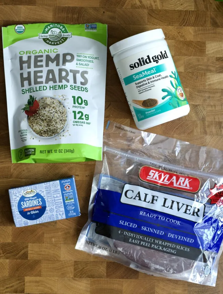 A stainless steel pan on the stove with gently cooked ground meat, prepared for dog food.