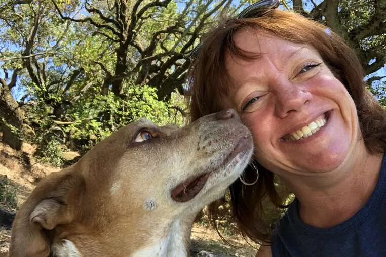 A thoughtful at-home pet sitter carefully observing a dog during a walk.