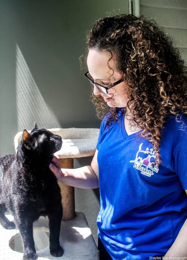 A woman gently holding a cat, demonstrating specialized care for felines