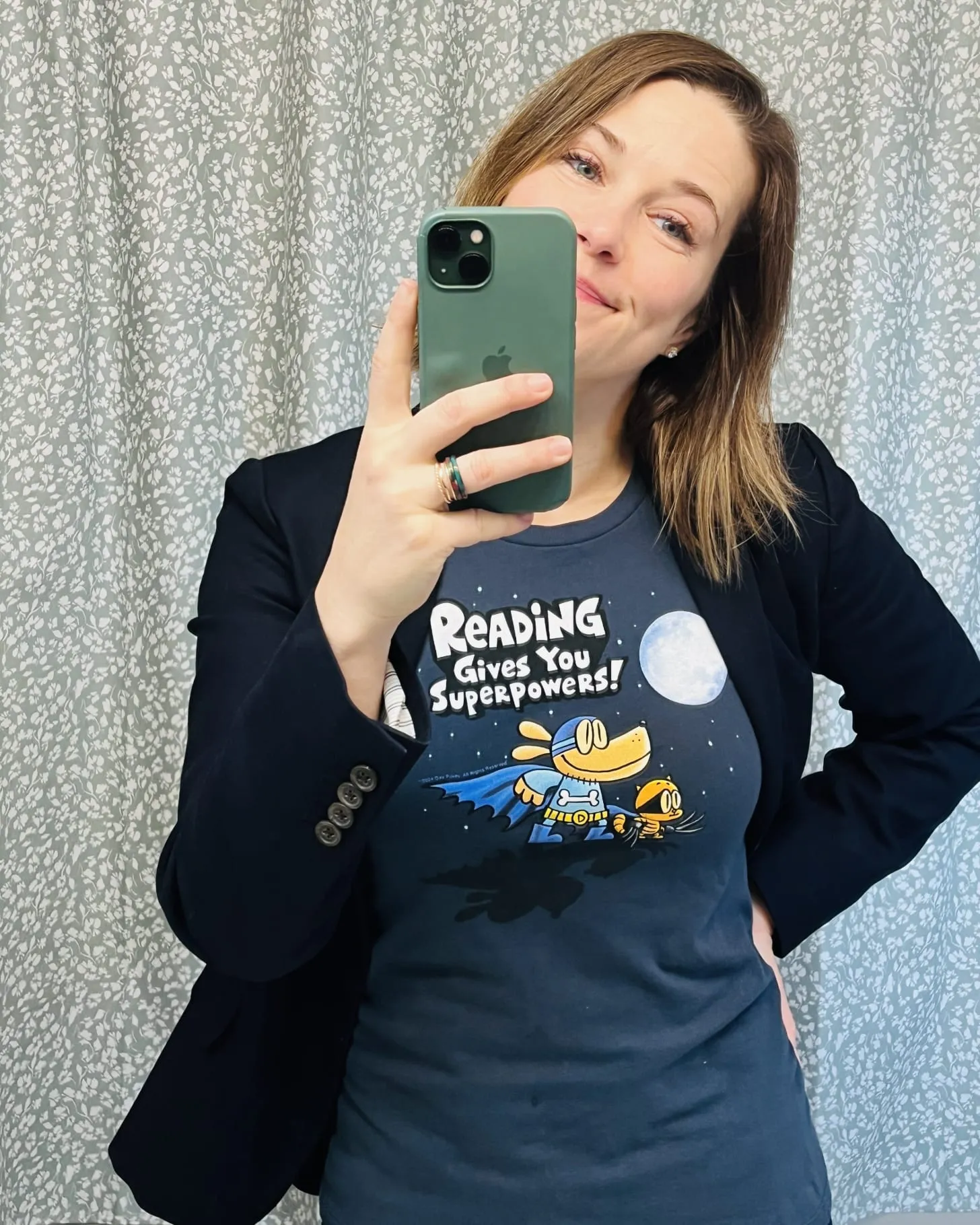 A woman proudly displays her Dog Man themed shirt, perfect for fans of the popular children's book series
