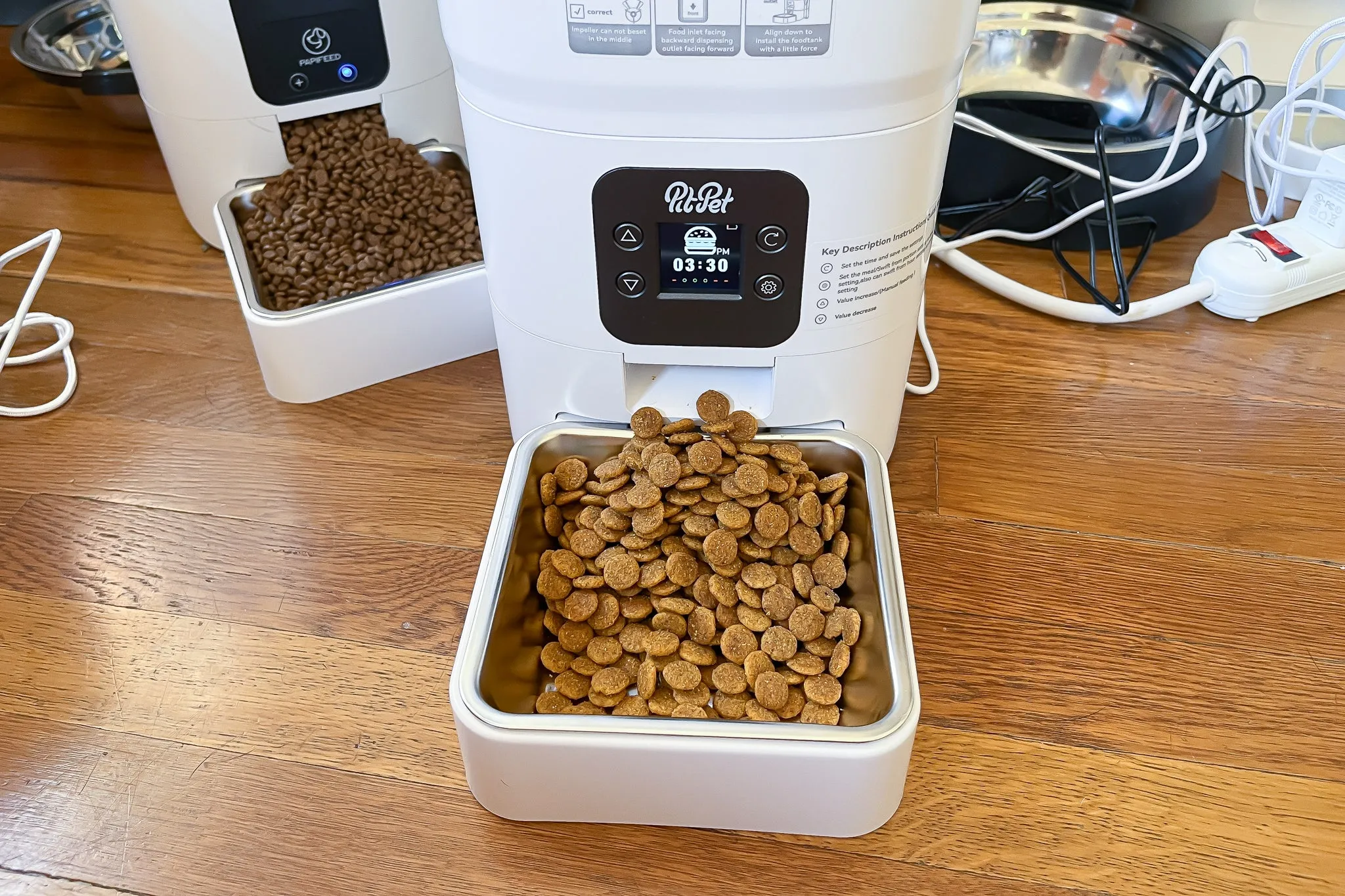 An automatic pet feeder, sleek and modern, dispensing dog kibble into a bowl.