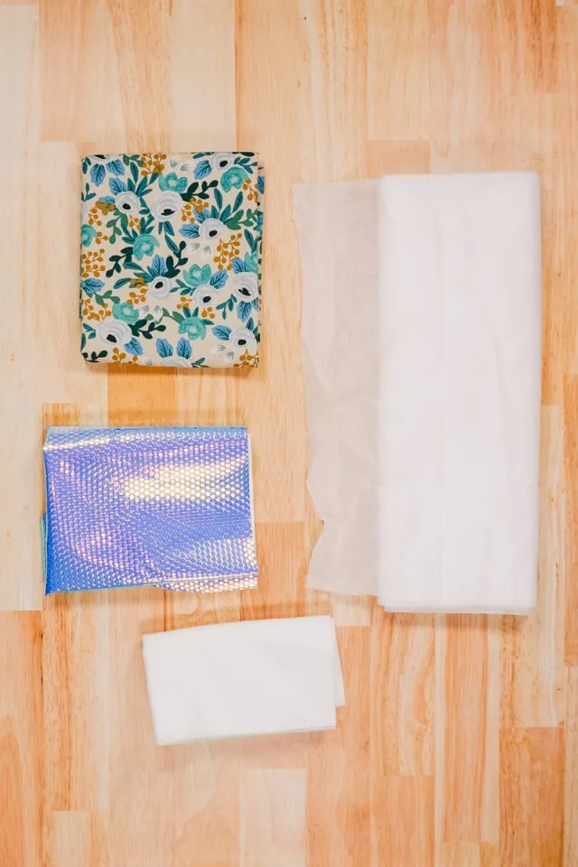 Assortment of fabrics and sewing tools laid out on a table