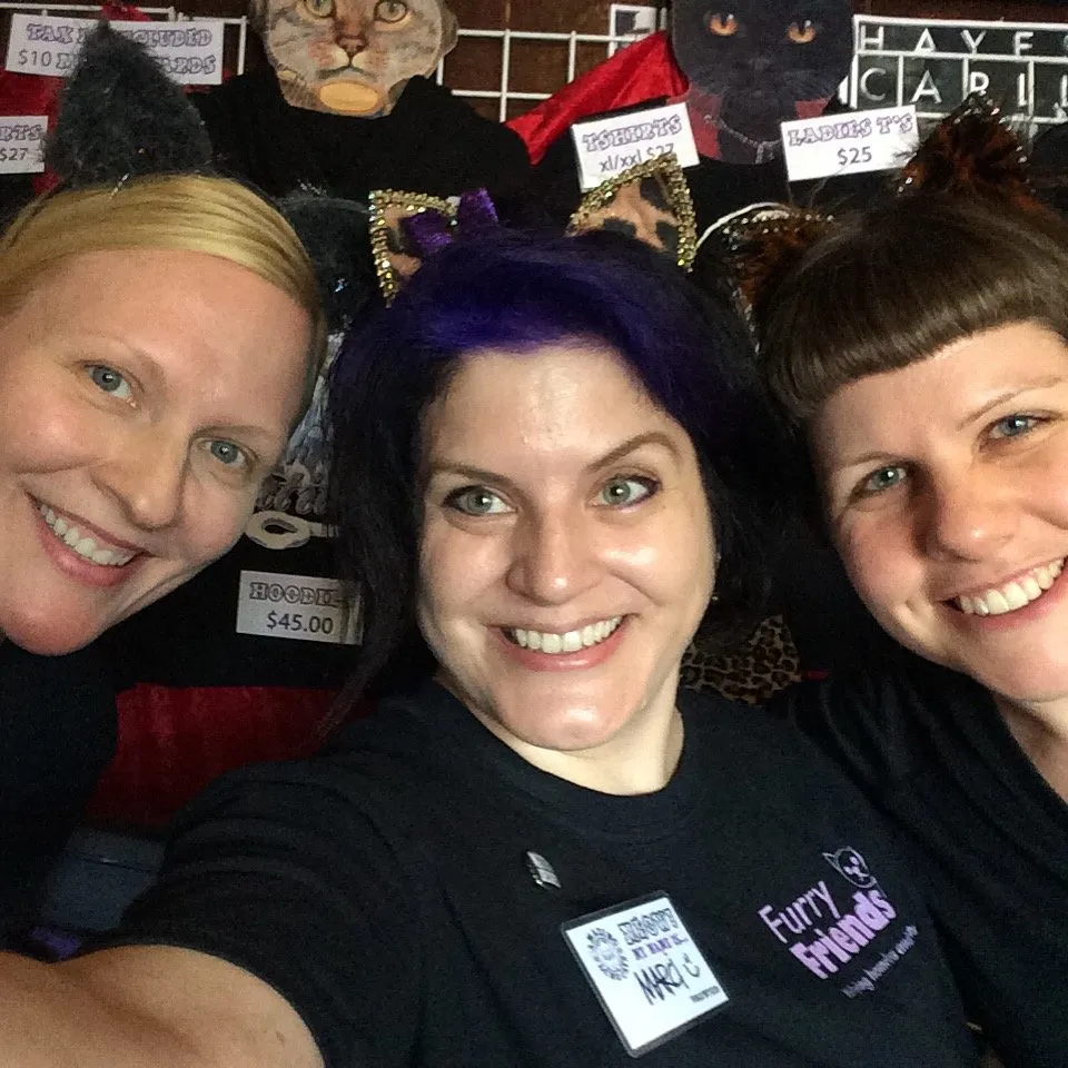 Audience interacting with Wiki cat at merch table