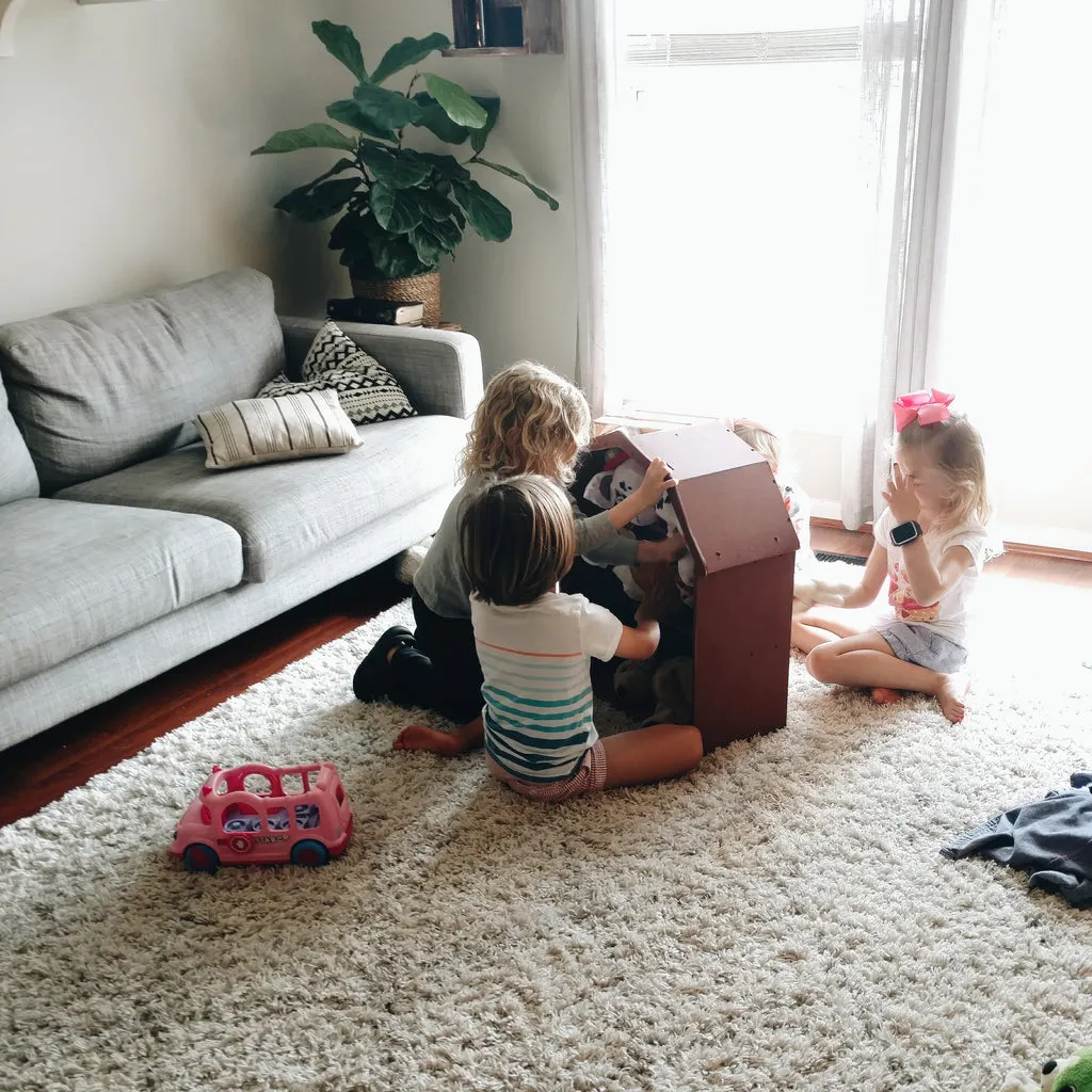 Children engaging in imaginative play with large blocks and stuffed dogs, building structures