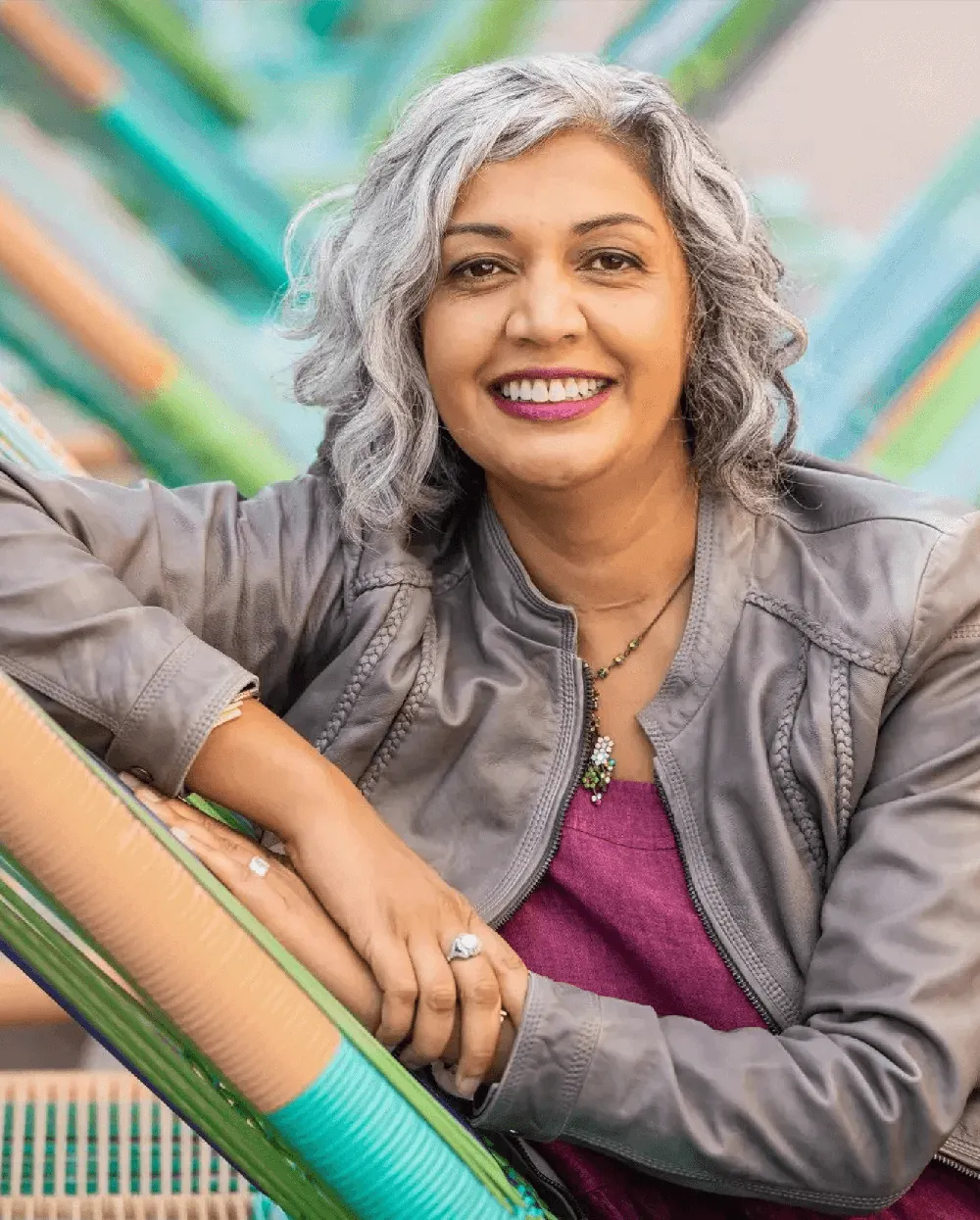 Dr. Mika Gupta, an award-winning neurologist and founder of Best Nest Wellness Mama Bird, smiling confidently