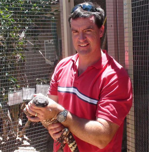 Dr Todd Driggers holding a gila monster during a wildlife tour in Phoenix