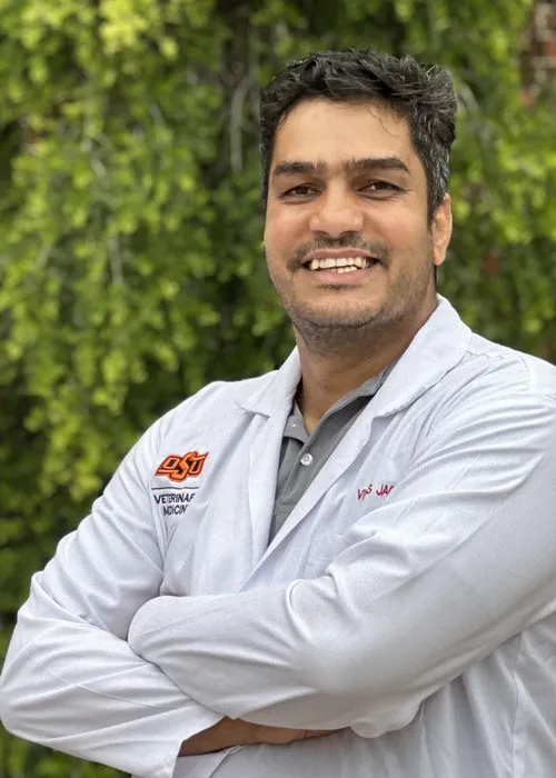 Dr. Vikas Jaglan, a veterinarian at Urgent Care Animal Hospital, smiling in a professional setting.