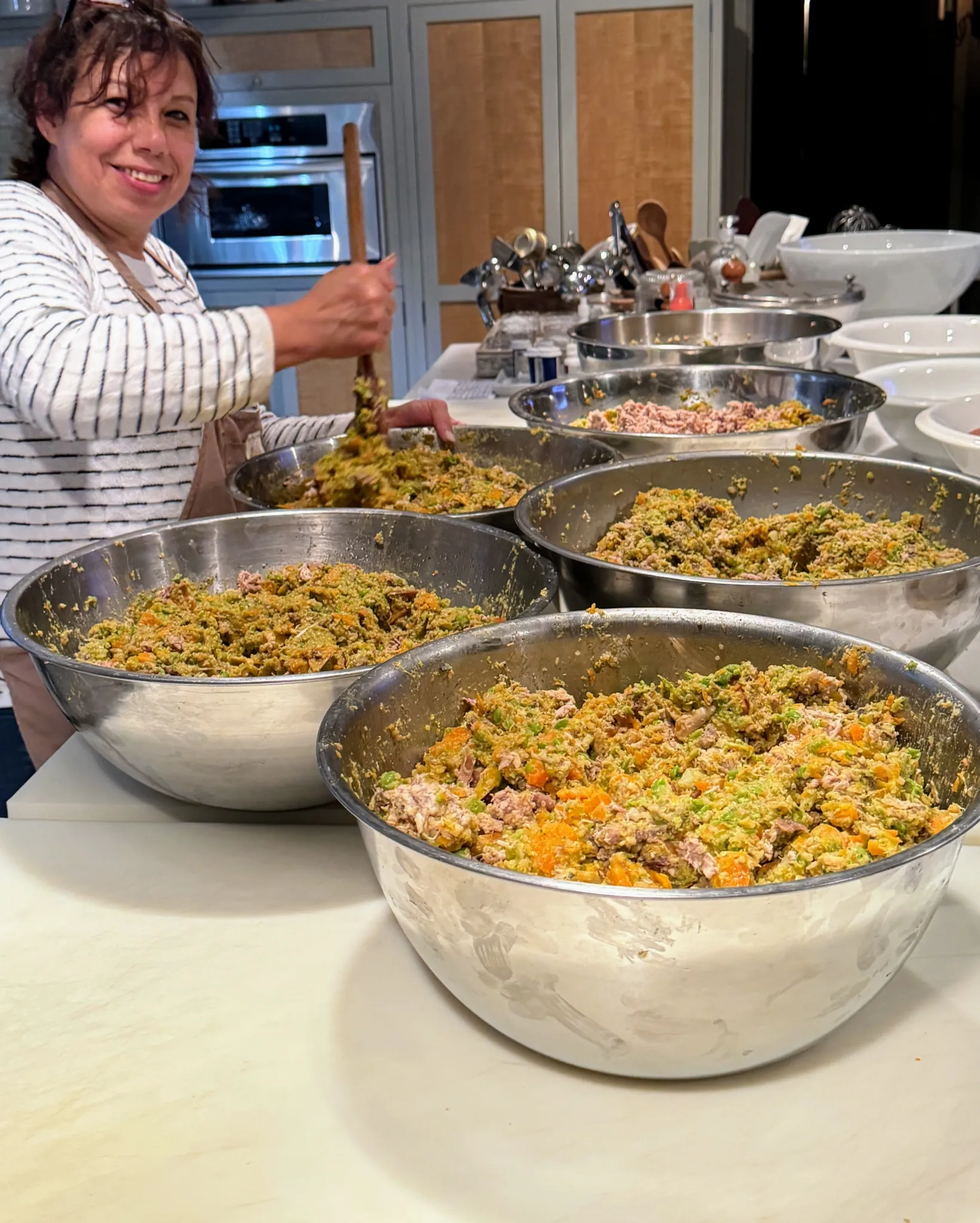 Elvira mixing the processed homemade dog food before it is portioned into containers.