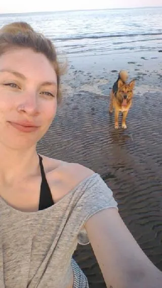 Fiona, a dedicated pet walker, enjoying a stroll with a canine companion in a sunny park in Amsterdam