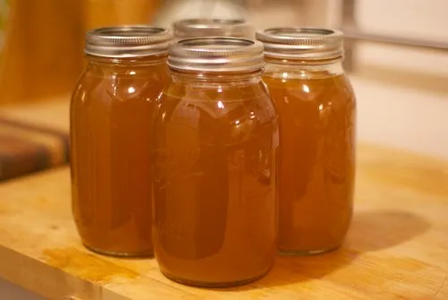 Freshly prepared chicken bone broth stored in glass jars