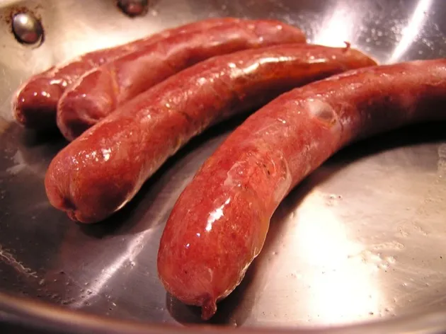Frying hot dogs in a skillet until crispy