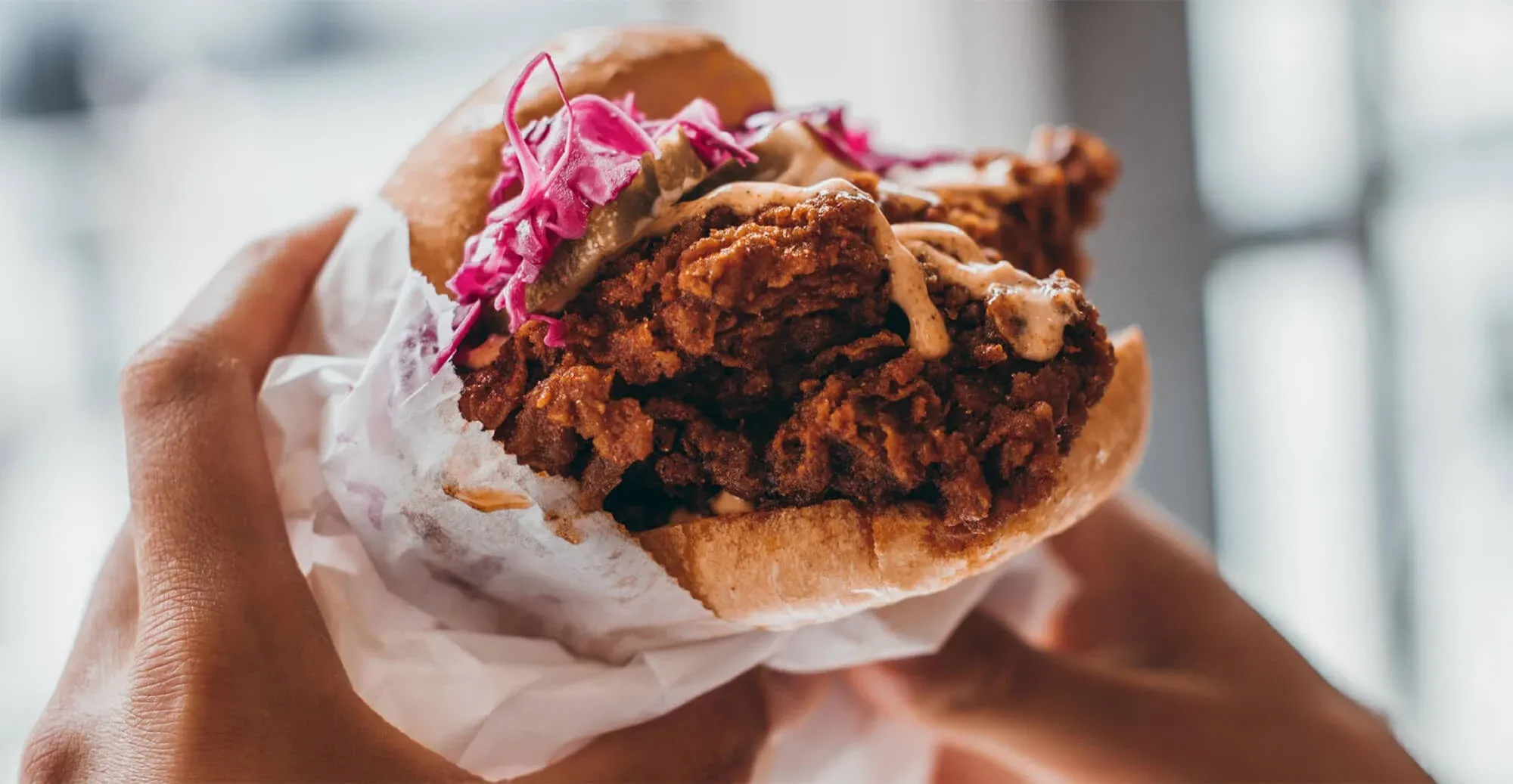 Iconic Pretty Bird Fried Chicken Sandwich with bold spices and fresh toppings