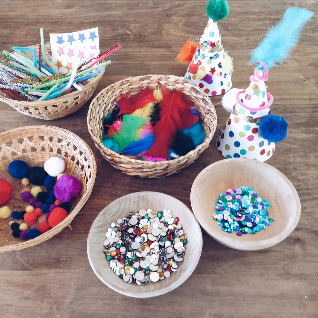 Kids decorating colorful party hats with various craft supplies at a table