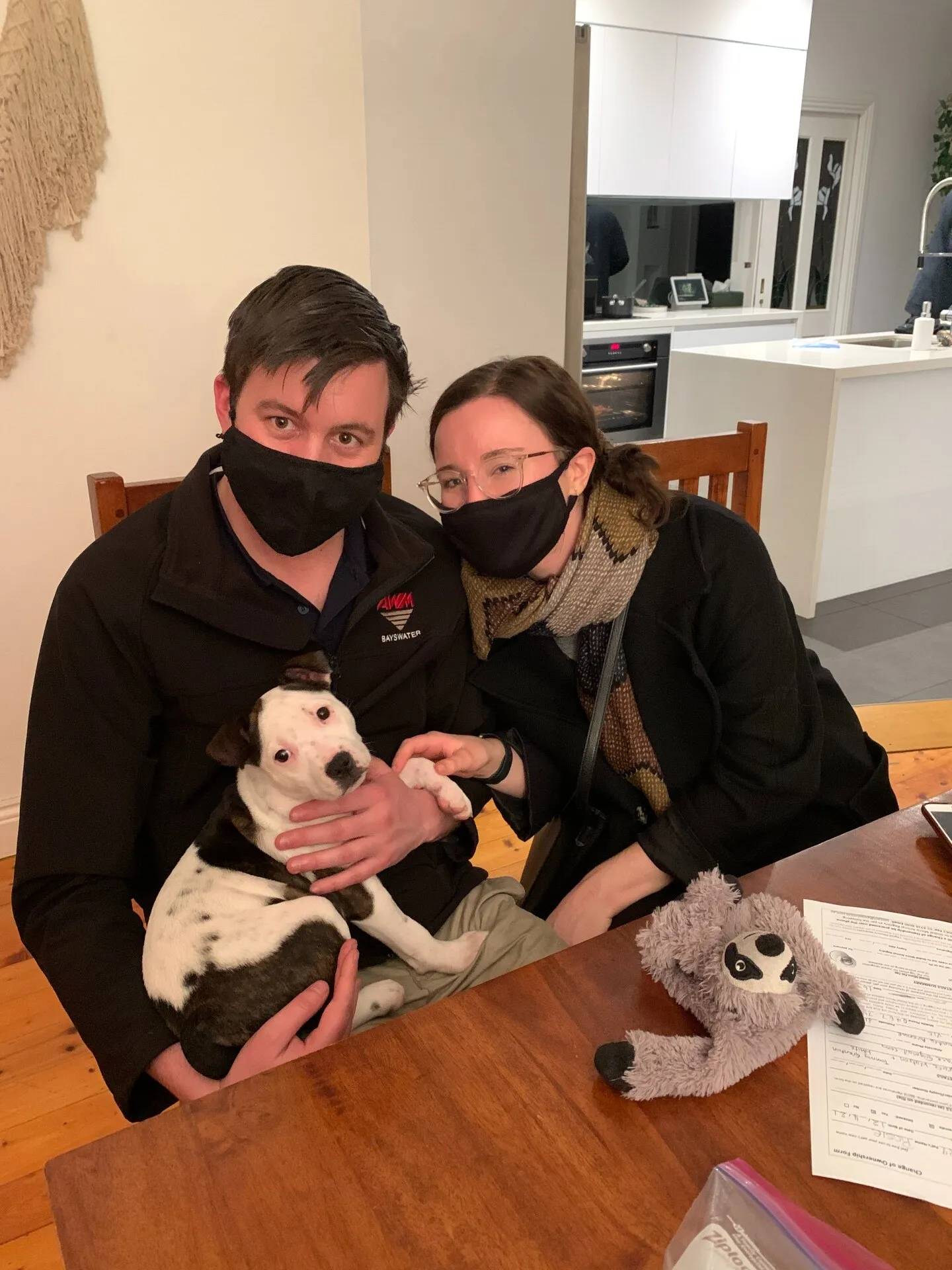 Meg and her partner holding Ruby, signing the adoption paperwork