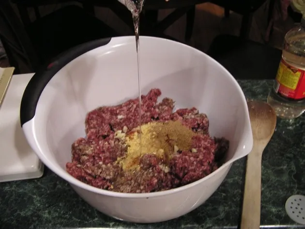 Mixing ground meat with spices and corn syrup