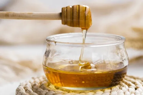 Natural honey pouring into a rustic bowl