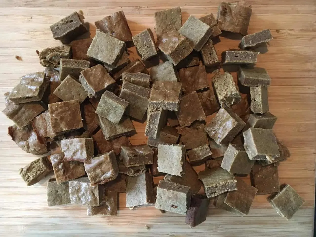 Numerous small, chopped pieces of liver cake arranged on a cutting board, ready for storage