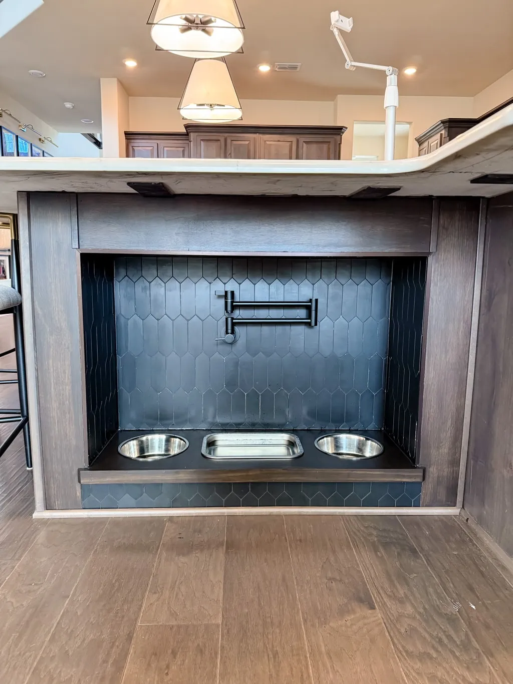 Placing stainless steel dog bowls into a finished built-in dog feeding station with a pot filler