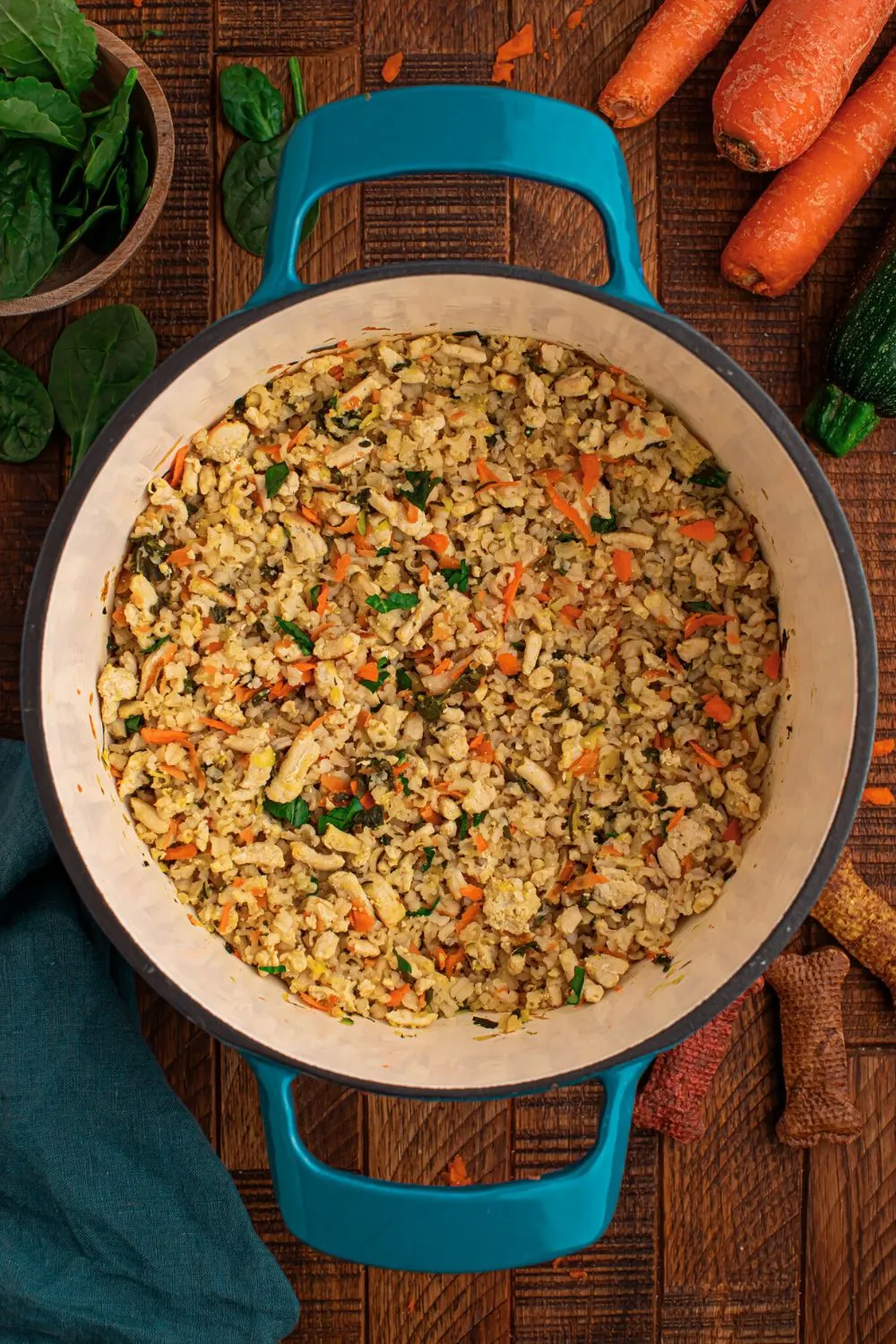 Raw ingredients for homemade dog food, including ground turkey, rice, and fresh vegetables, combined in a large pot.
