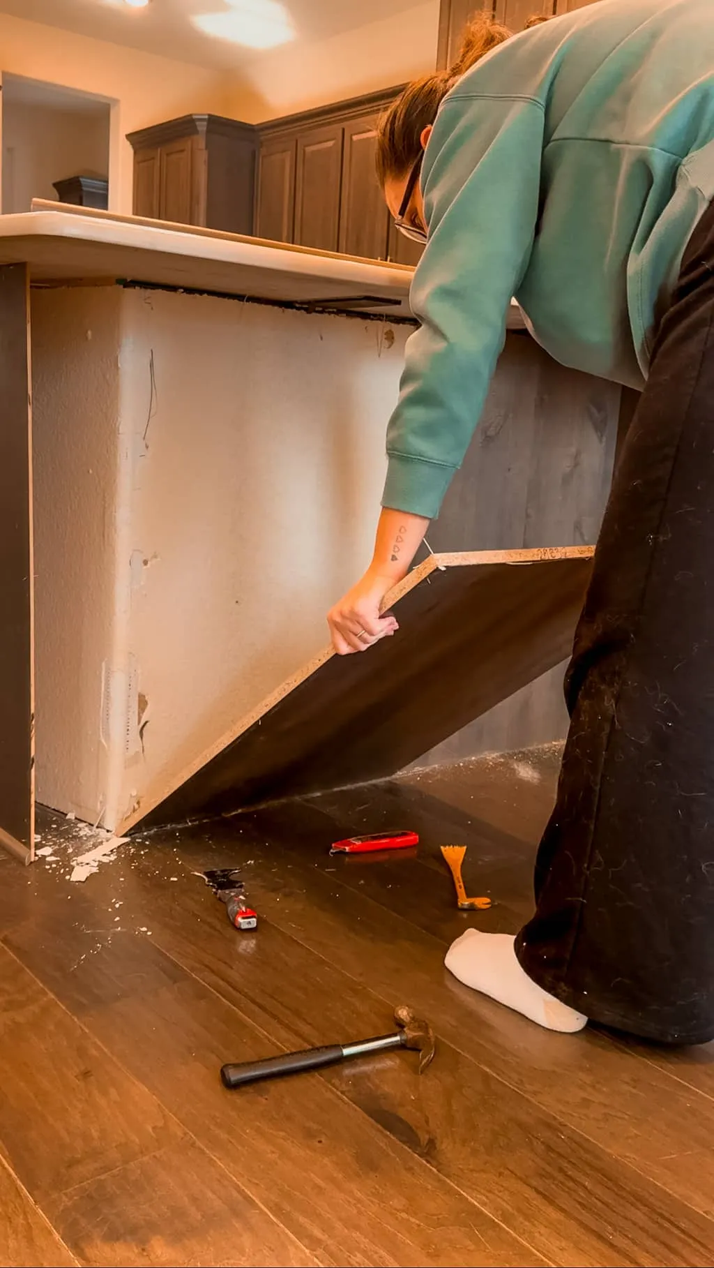 Removing existing paneling from the side of a kitchen island to create space for a dog feeding station