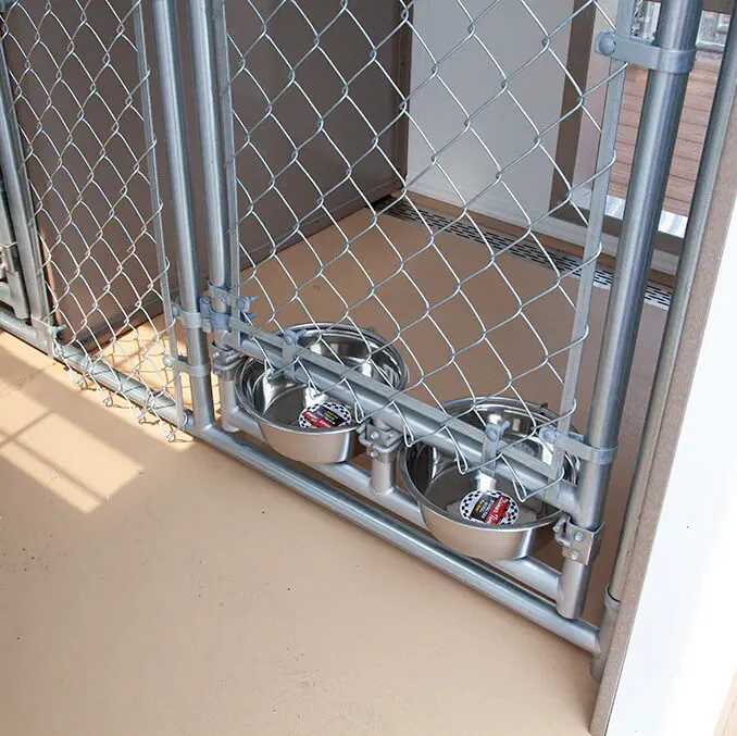 The interior view of a well-equipped dog kennel with a durable floor and insulated walls