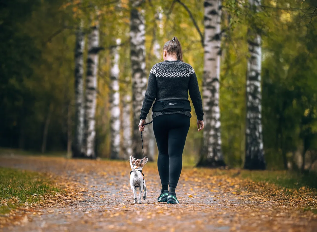 Woman hiking with Rush belt and small dog