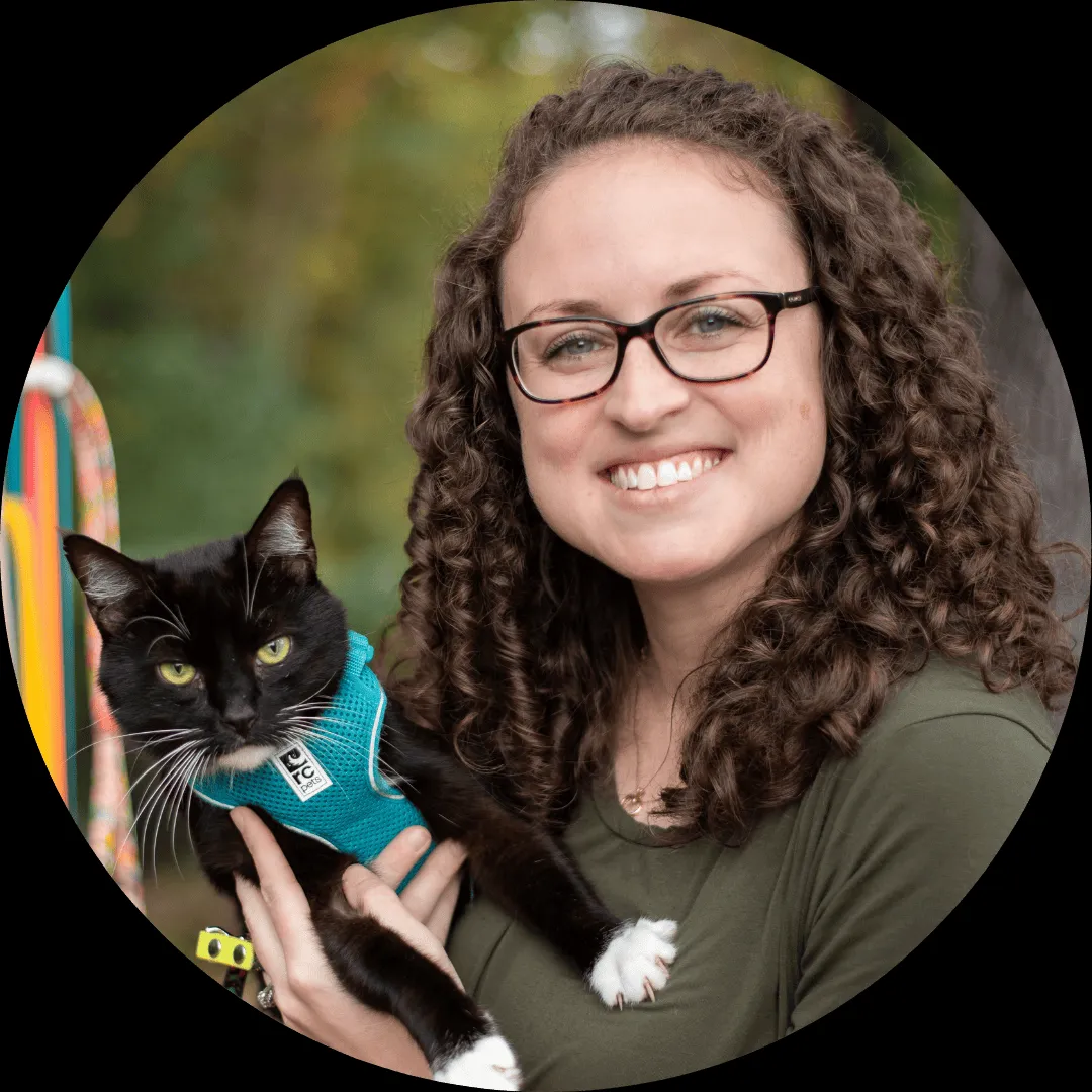 woman holding cat outside and looking at camera