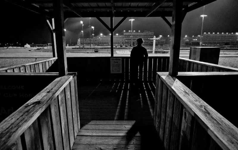 Bas Nichols horse trainer observing a thoroughbred during a morning workout at the track
