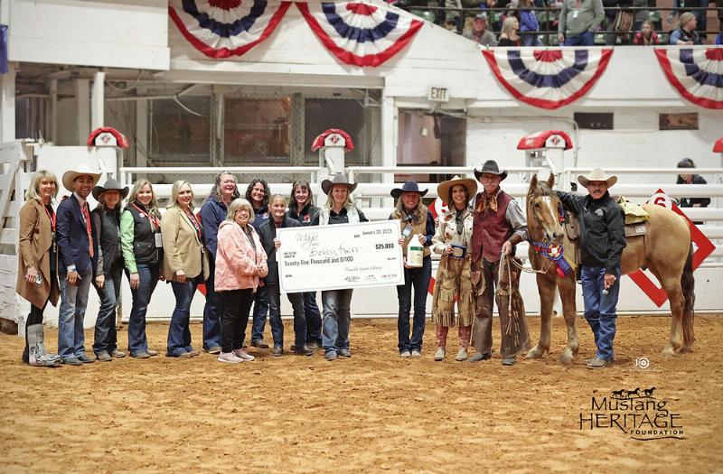 Bobby Kerr the horse trainer performing at liberty with two mustangs in a large stadium