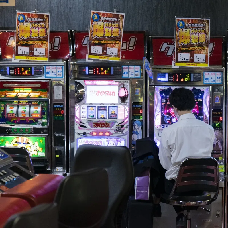 A wide shot of a modern casino horse racing game like Fortune Cup, showing the miniature track, the large overhead screens, and players at their individual betting stations.