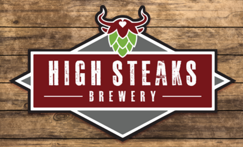 A panoramic view of the beautifully landscaped paddock area at Delaware Park before a horse race, with trainers and owners watching.