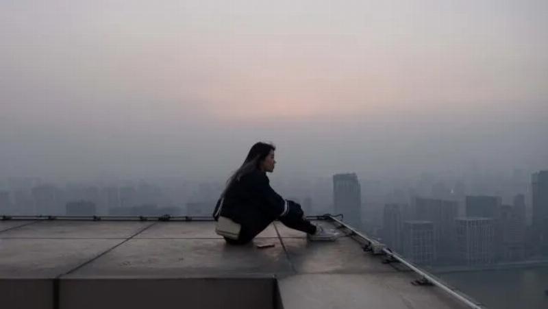 A joyful woman celebrating as her parrot, wearing a harness, flies back to her outstretched hand in a sunny garden. The parrot looks happy and engaged. Concept: Trust and Freedom in Bird Training.