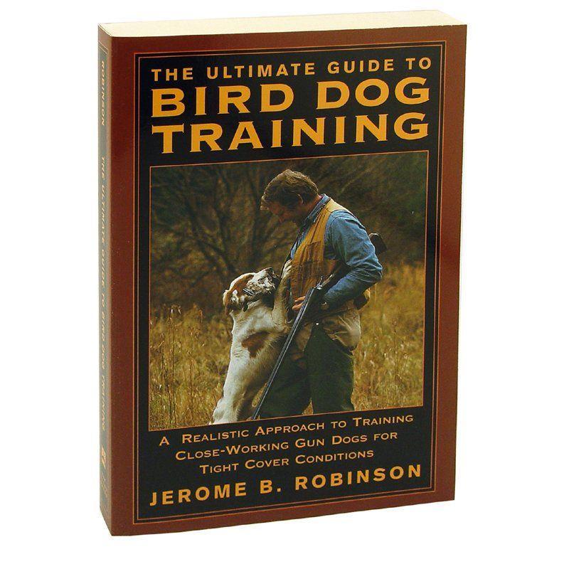 A comprehensive guide book on training gun dogs, open on a table with hunting gear around it.