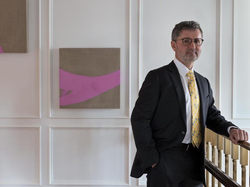 A horseplayer analyzing a Daily Racing Form next to a laptop displaying Horse Watch alerts.
