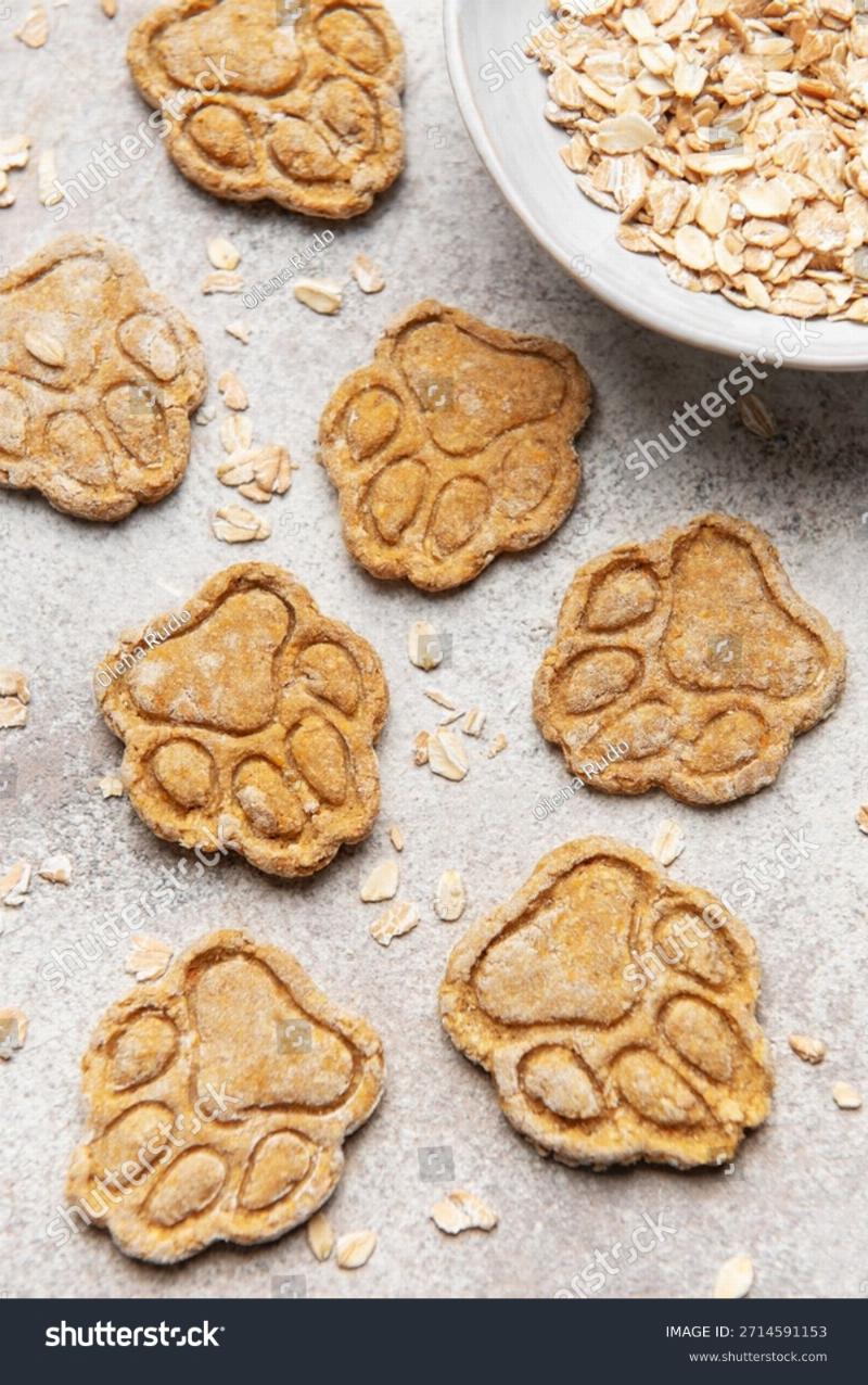 Close-up of homemade dog training treats, some shaped like small bones, on a rustic wooden surface.