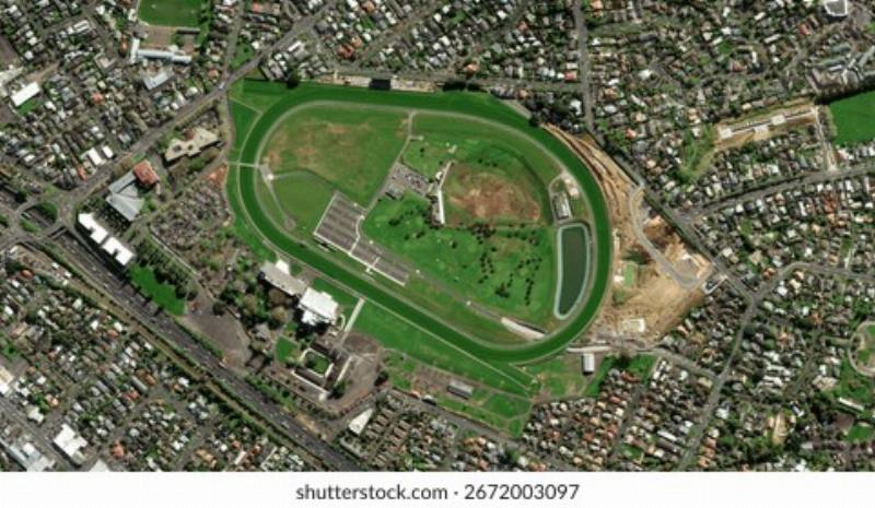 A panoramic view of horse racing on the rolling green hills of Epsom Downs, illustrating why horse racing tracks are called downs.