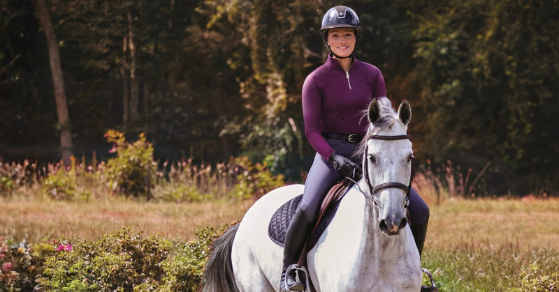 A collection of reins used to train a horse, including side reins and draw reins, displayed on a saddle blanket.