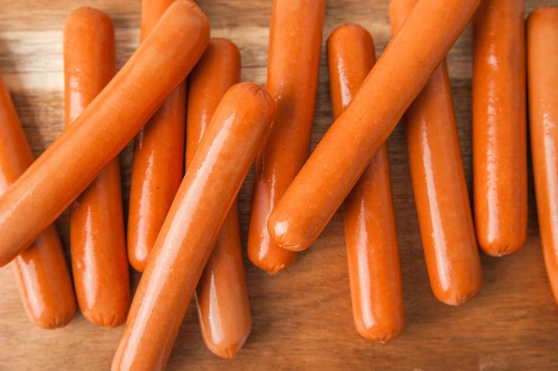 Creative hot dog recipe ideas from a book, featuring vibrant toppings and diverse sausages