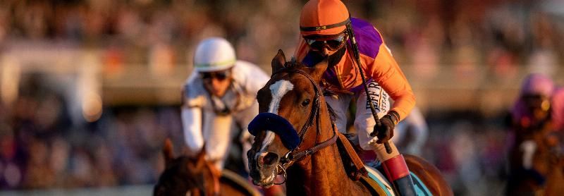 Two thoroughbred horses racing neck and neck towards the finish line at Churchill Downs, with the iconic twin spires in the background.