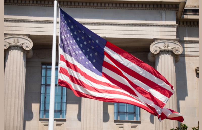 A solitary horse trainer missing the morning mist, viewed from a distance on a vast, open field, highlighting the isolation of the job.